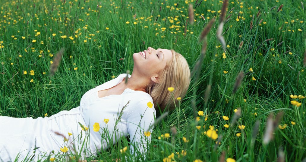Blond woman lying in field
